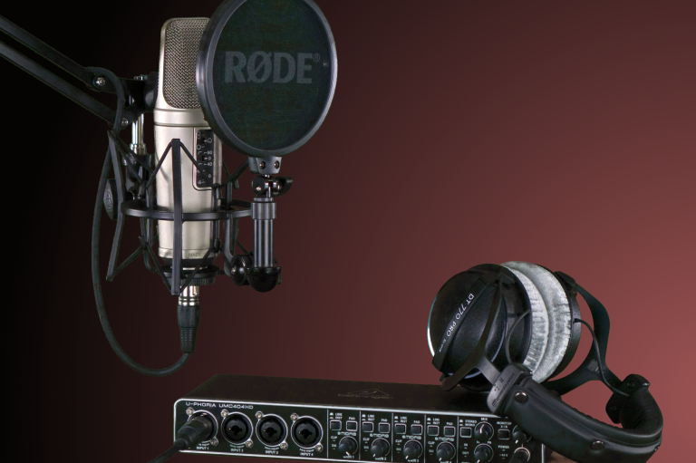 Mikrofon mit Popfilter und Kopfhörer auf einem Audio-Interface.