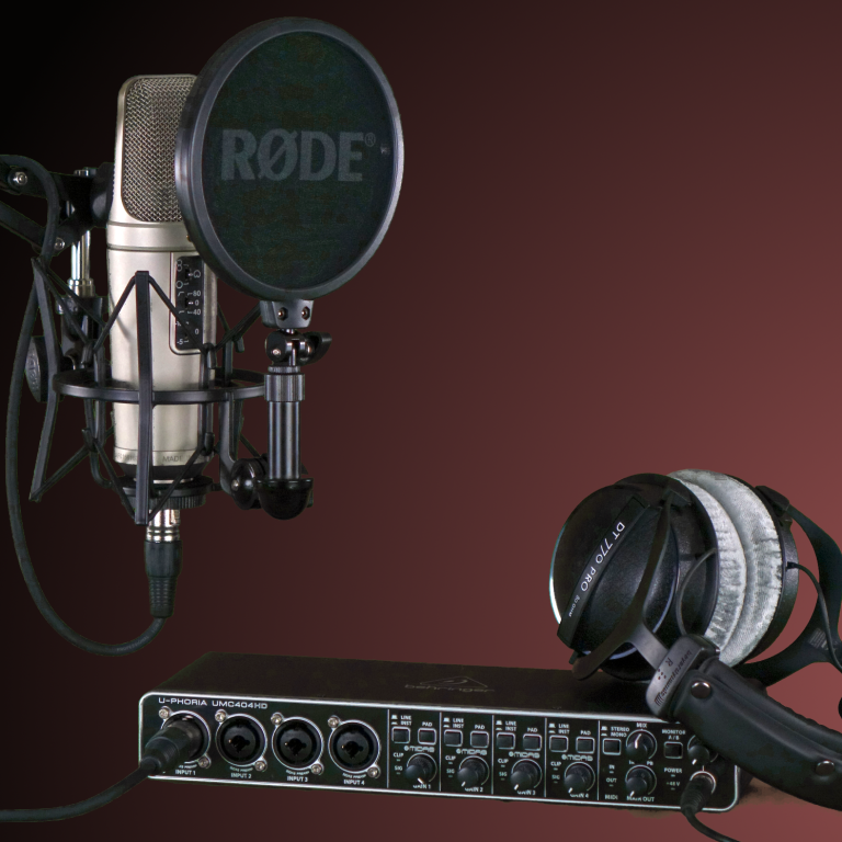 Mikrofon mit Popfilter und Kopfhörer auf einem Audio-Interface.
